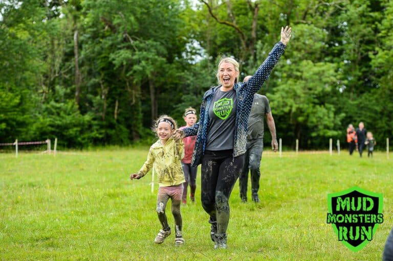 Children and adults enjoying muddy fun at Mud Monsters Run event.